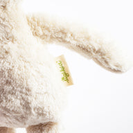 Bio-Kuscheltier Schaf Nahaufnahme Arm & Sigikid Logo