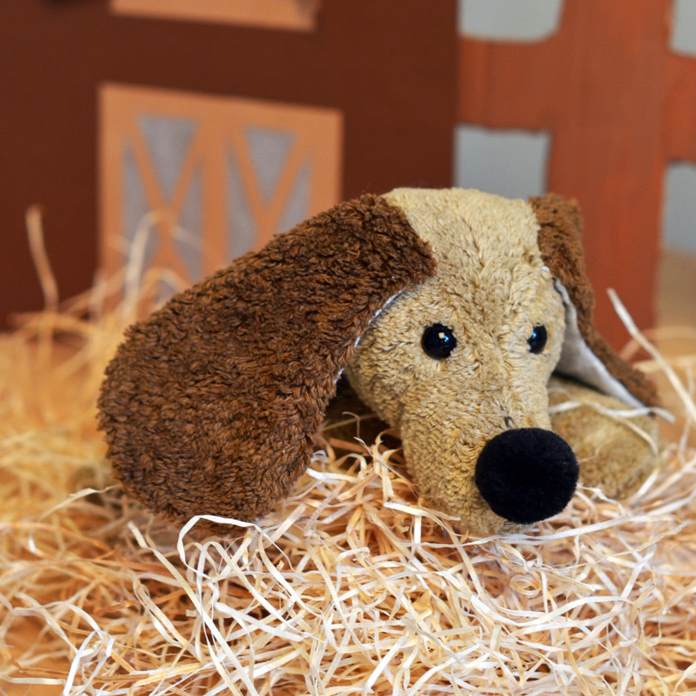 Steiner Bio Kuscheltier Hund Robin auf Dekomaterial liegend